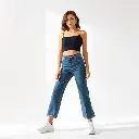 A modern streetwear fashion photo an adorable woman with soft features wearing high-waisted Y2K wide-leg dark wash denim jeans, a black crop top, and sneakers. Gentle soft light, vibrant complimentary colors, diffu.webp