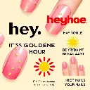 A digital advertisement, vertical layout, extreme macro close-up, features five artificial nails with pink-to-gold gradient, star and line decorations. Bold black 'hey,' and smaller 'IT'S GOLDEN HOUR', large red 'h.webp