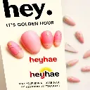 High-angle view of a digital advertisement depicting five sculpted clay nails with pink-to-gold gradient, star, and line accents.  Bold black 'hey,' and smaller 'IT'S GOLDEN HOUR' text above.  Large red 'heyhae' lo.webp