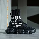 Precise architectural color photography showcases a futuristic black high-top sneaker with ribbed knit texture, thick rubber sole, and bold white and red typography 'JUST BE NICE GAME IS RESETTED FOR NEW FUTURE STA.webp