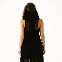 A black halter-neck fringe dress with layered tassels, sleeveless and backless, styled in a western cowgirl aesthetic against a plain white background. Surreal infrared tones, warm, slightly dark, soft professional.webp